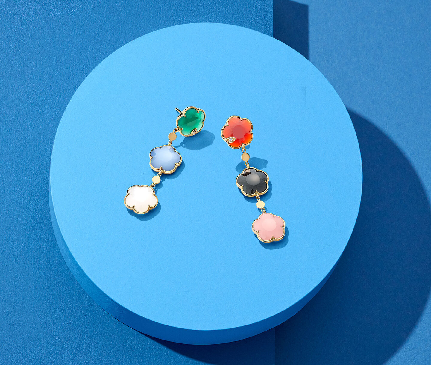 Pasquale Bruni Petit Joli drop earrings on a blue background.